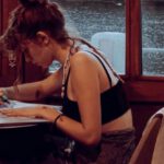 Gamification, Learning Benefits - A woman sitting at a table writing in a notebook