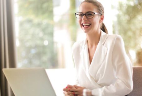 LinkedIn, Career Advancement - Laughing businesswoman working in office with laptop