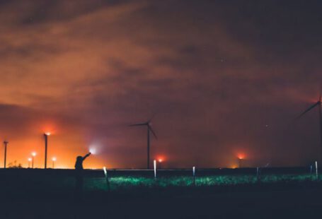Green Technology, Energy Industry - Photography of Person Holding Flashlight Near Windmills during Night Time