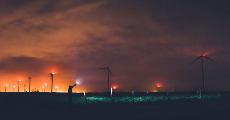 Green Technology, Energy Industry - Photography of Person Holding Flashlight Near Windmills during Night Time