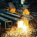 IoT, Industries - A worker welding steel bars with sparks