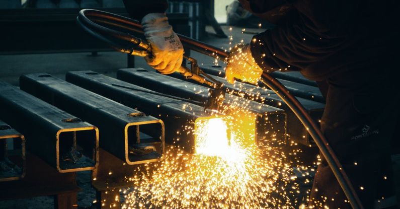 IoT, Industries - A worker welding steel bars with sparks